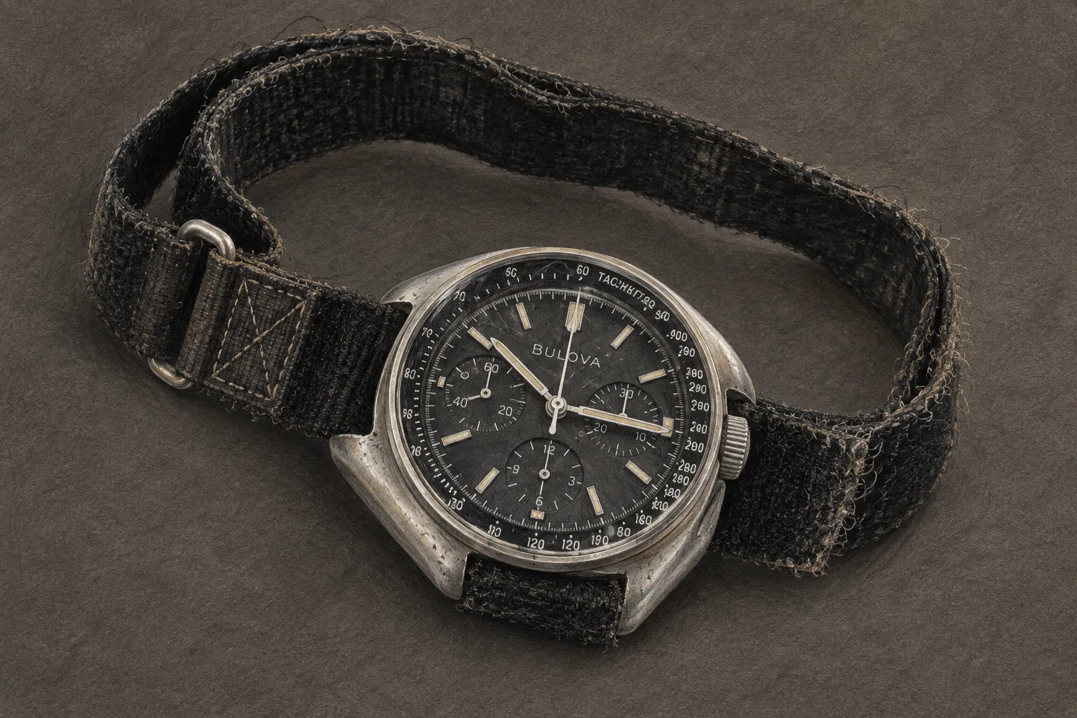 Художественная иллюстрация исторического чёрного хронографа Bulova с потёртым тканевым ремешком
